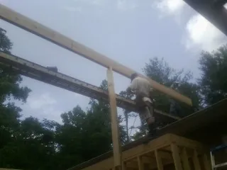 Carpenter setting a ridge beam over a new addition frame — Ice Dam Removal by Roofing Brothers in Port Royal