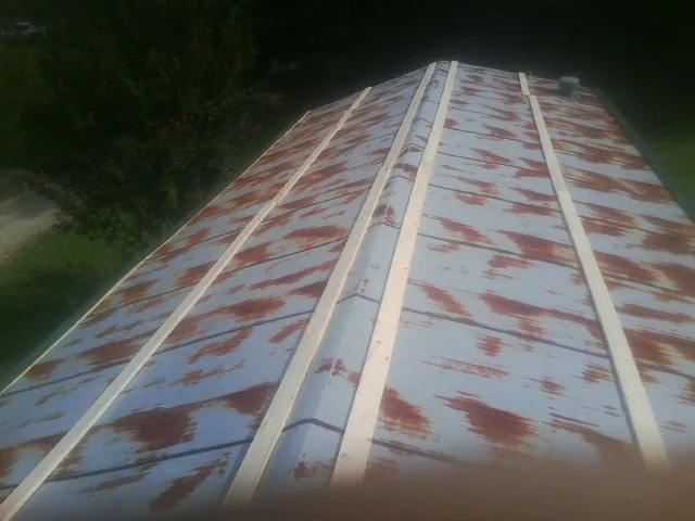 Rusted metal roof panels with new wood purlins before replacement — Storm Damage Roof Repair in Port Royal by Roofing Brothers